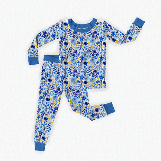 A two-piece pajama set with a long-sleeve top and pants, featuring a vibrant blue and yellow floral pattern of the Maine wildflowers