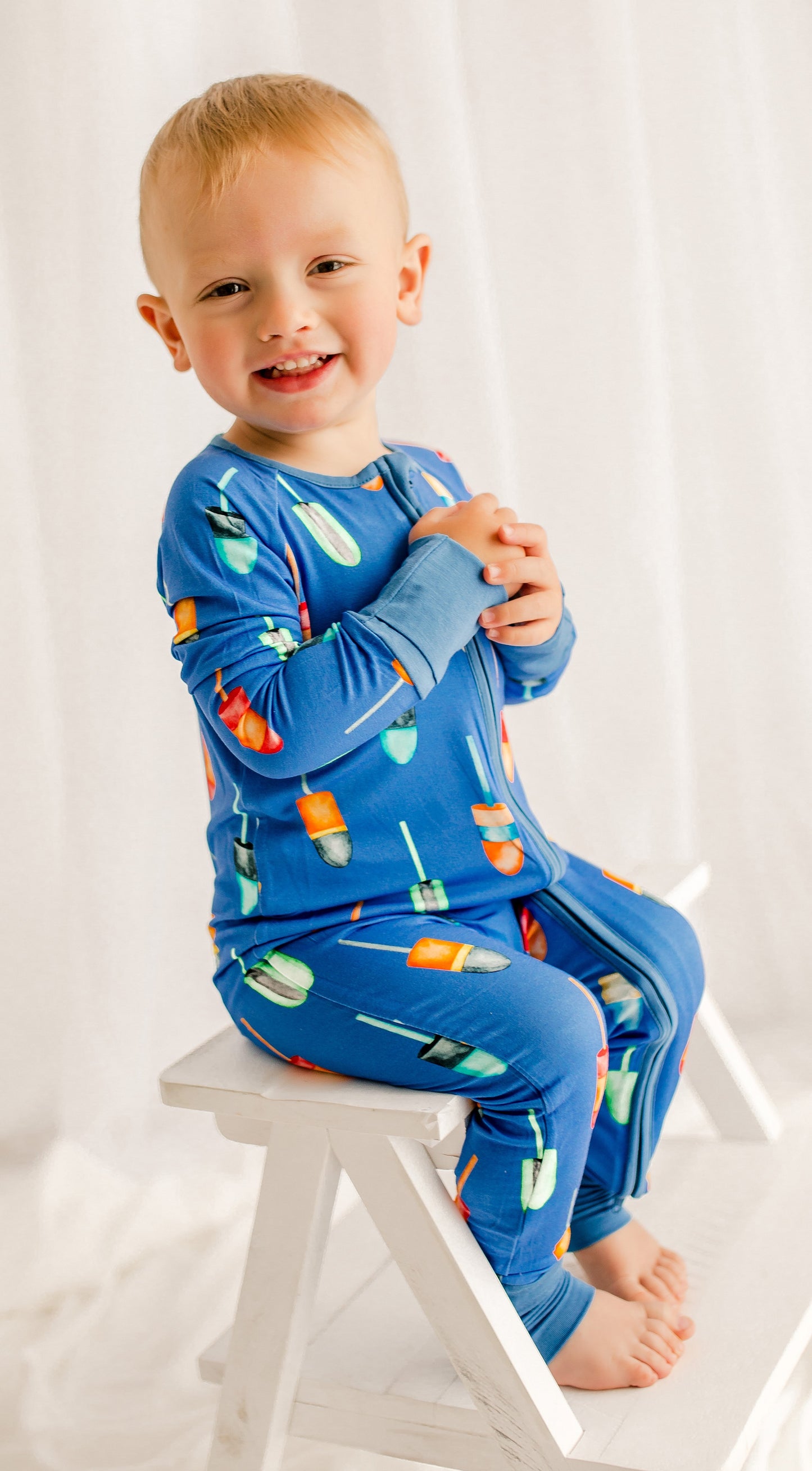 Child wearing buoys of all different colors on a blue background