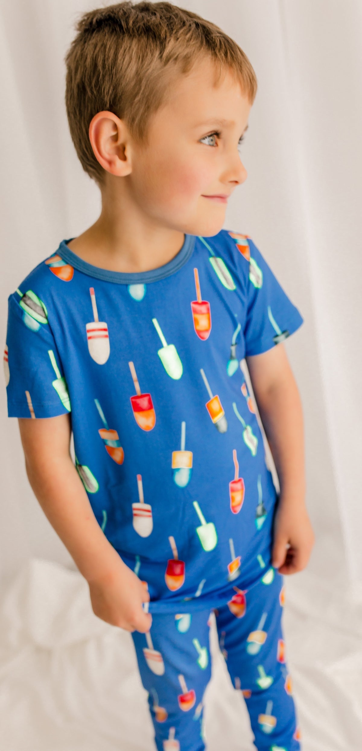 Child wearing family buoys of all different colors on a blue background