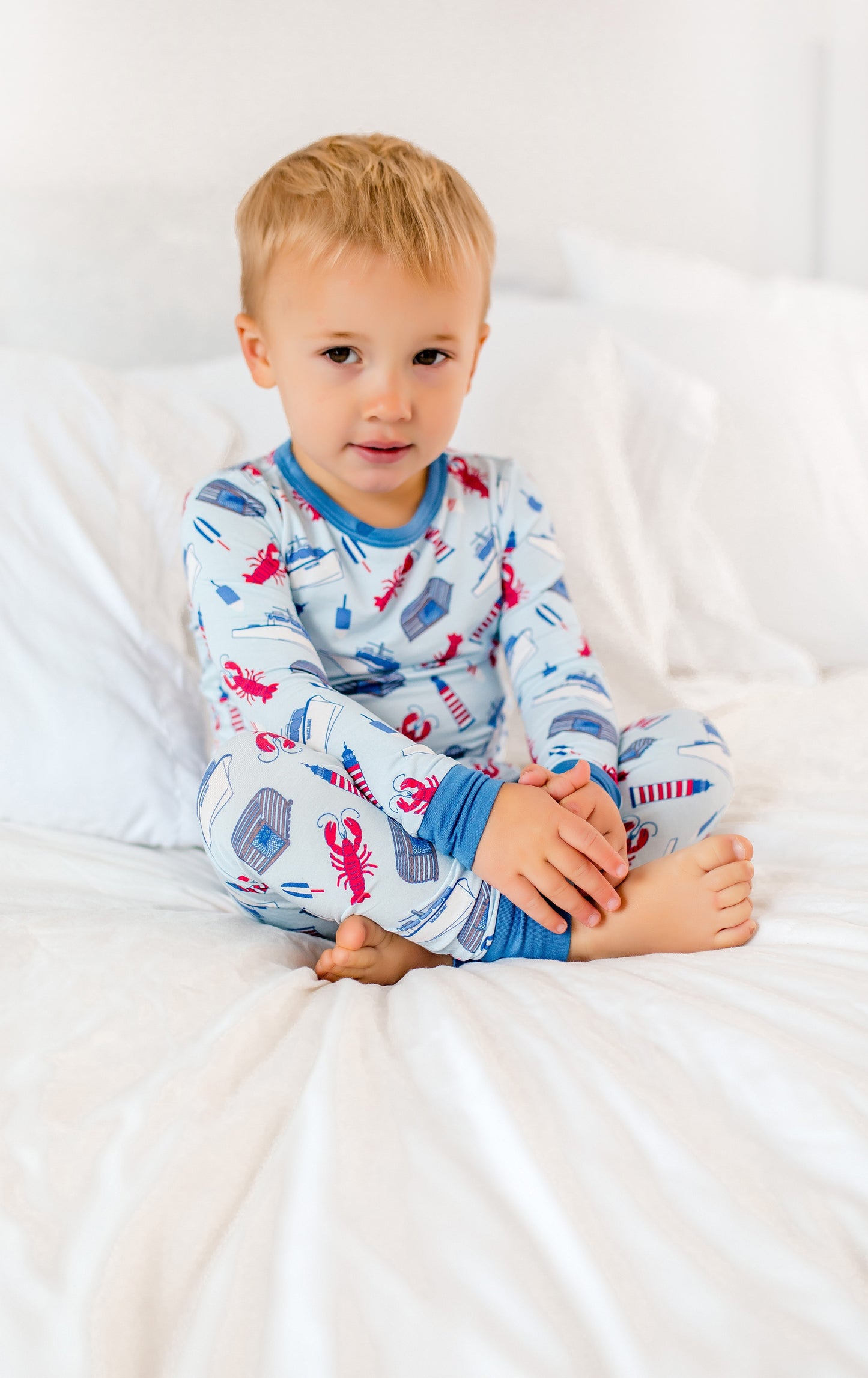 Maine coastal lobster print with red lobsters, fishing boats, striped buoys, and lighthouse icons on light blue fabric