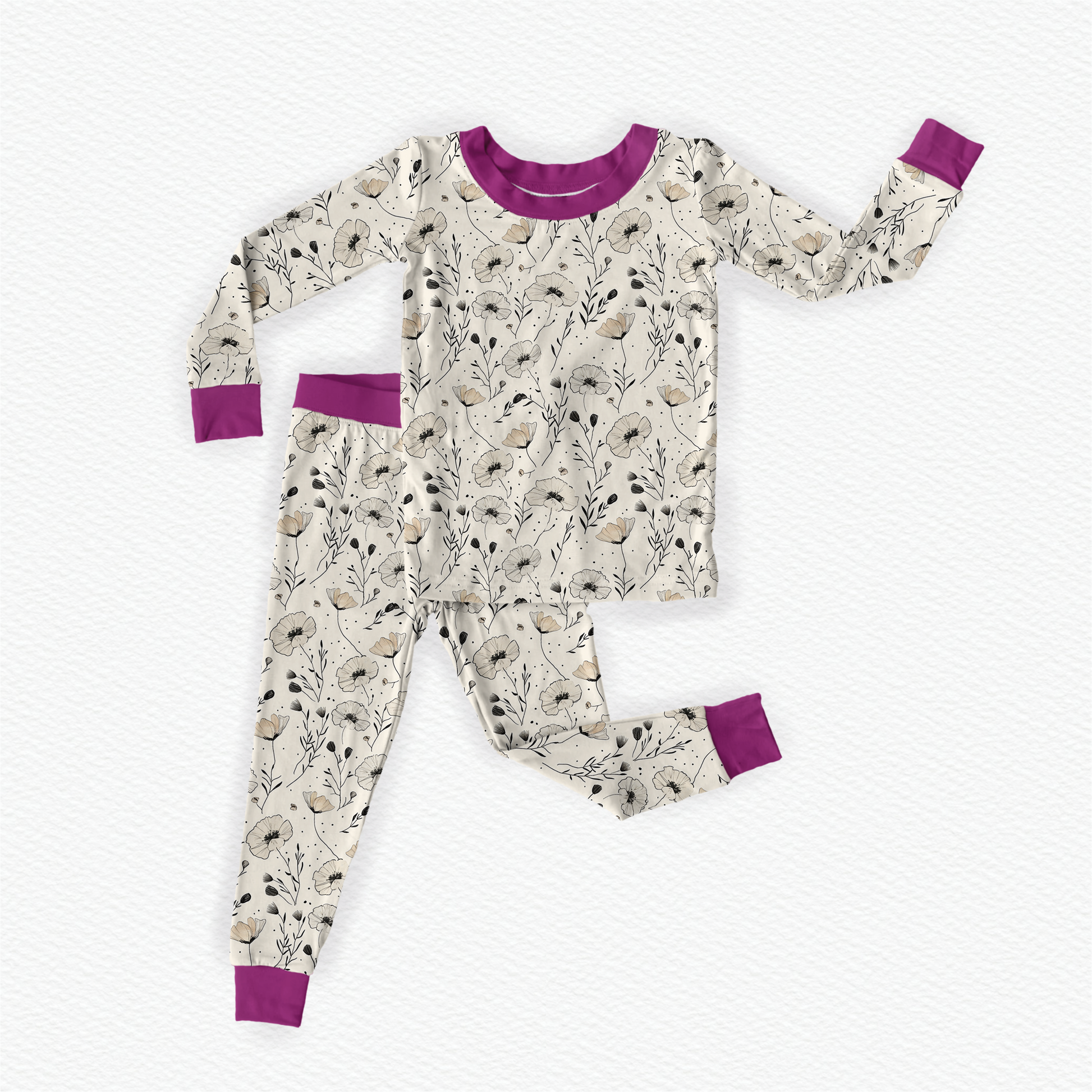 Children's pajama set with a floral poppy pattern on an off white background and purple accents. 