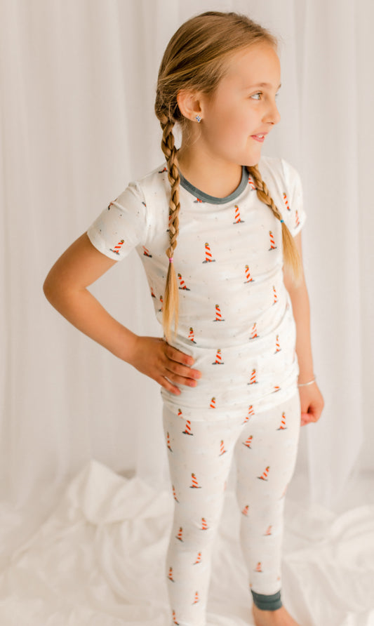 Young girl wearing a white pajama set with  Maine lighthouse 