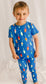 Child wearing a blue pajama set with colorful buoys all over 