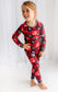 Child wearing red and black plaid pajamas with themes of forest trees and a moose 