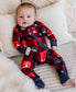 Baby wearing a red and black plaid onesie with images of trees in black and white and a white moose 