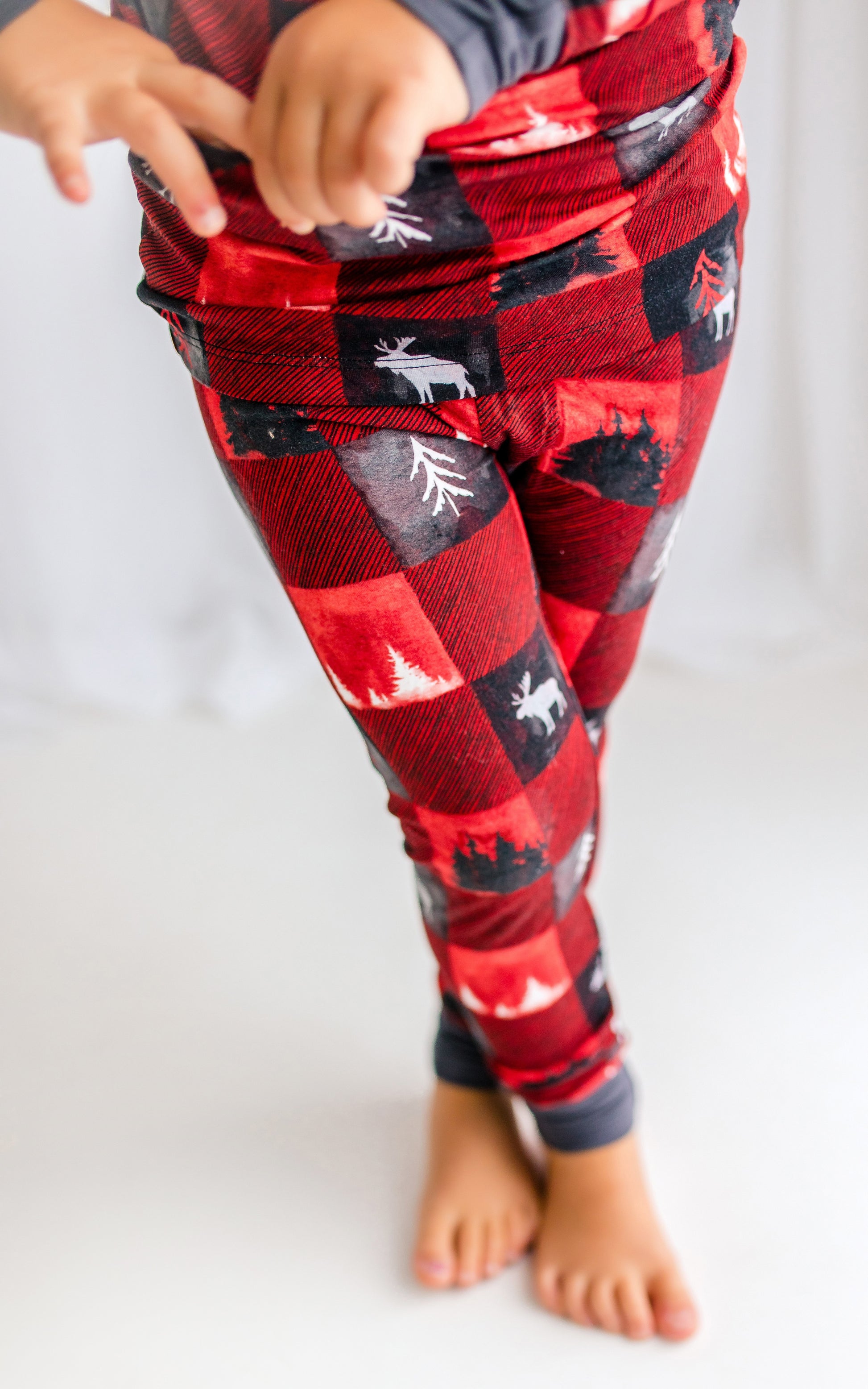 Red plaid pajama pants with black and red plaid pattern, maine forest trees and the largest maine animal, the moose  