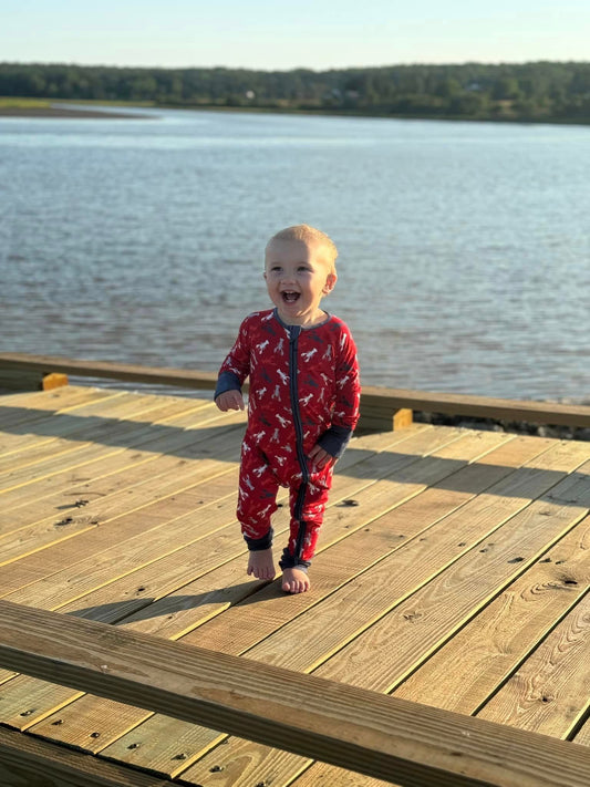 Child standing by the ocean wearing the Abel print of red white blue and grey maine lobsters 
