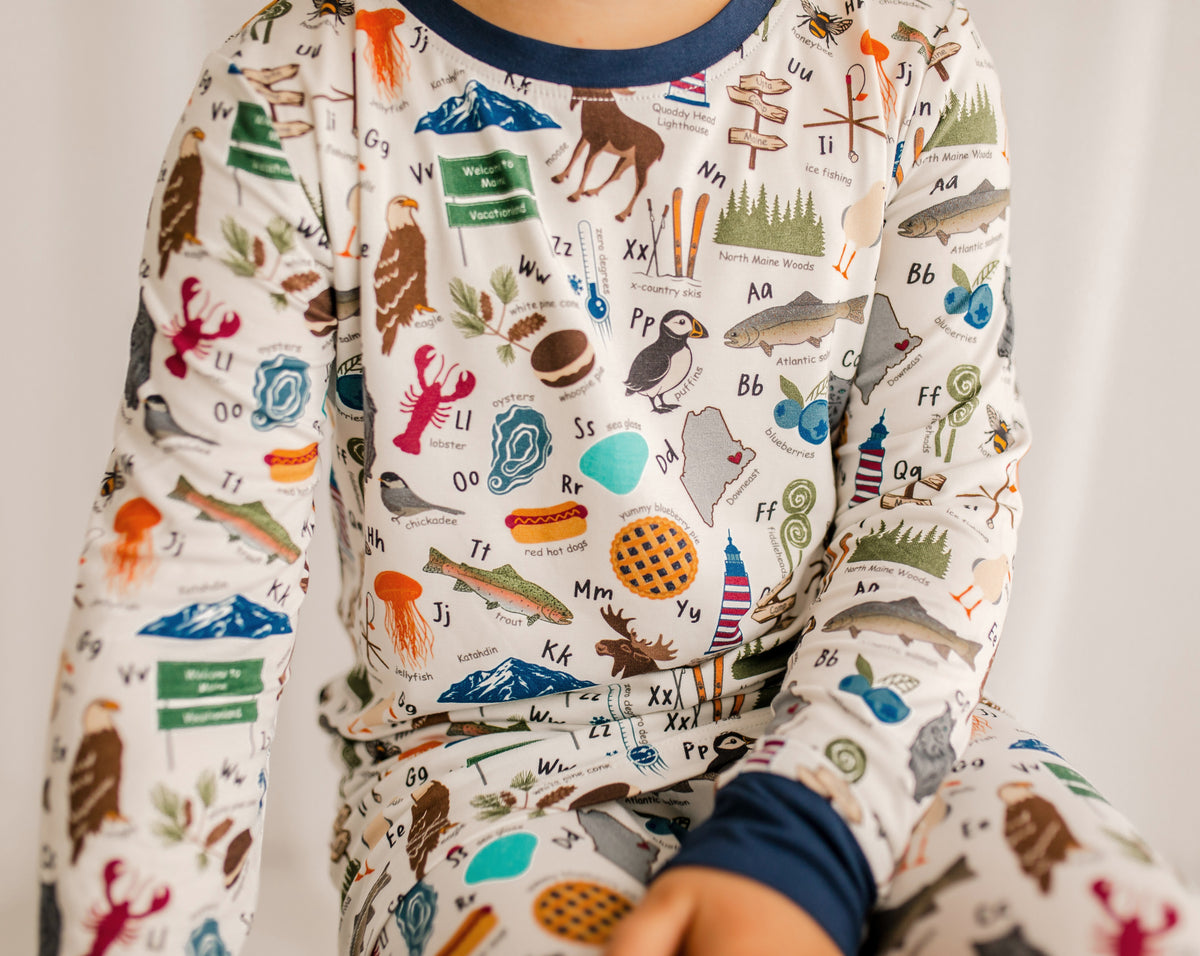 Children's pajama set with blueberries, moose, lobsters, waffles, hotdogs, oysters, chickadee, and so much more to make the maine alphabet 