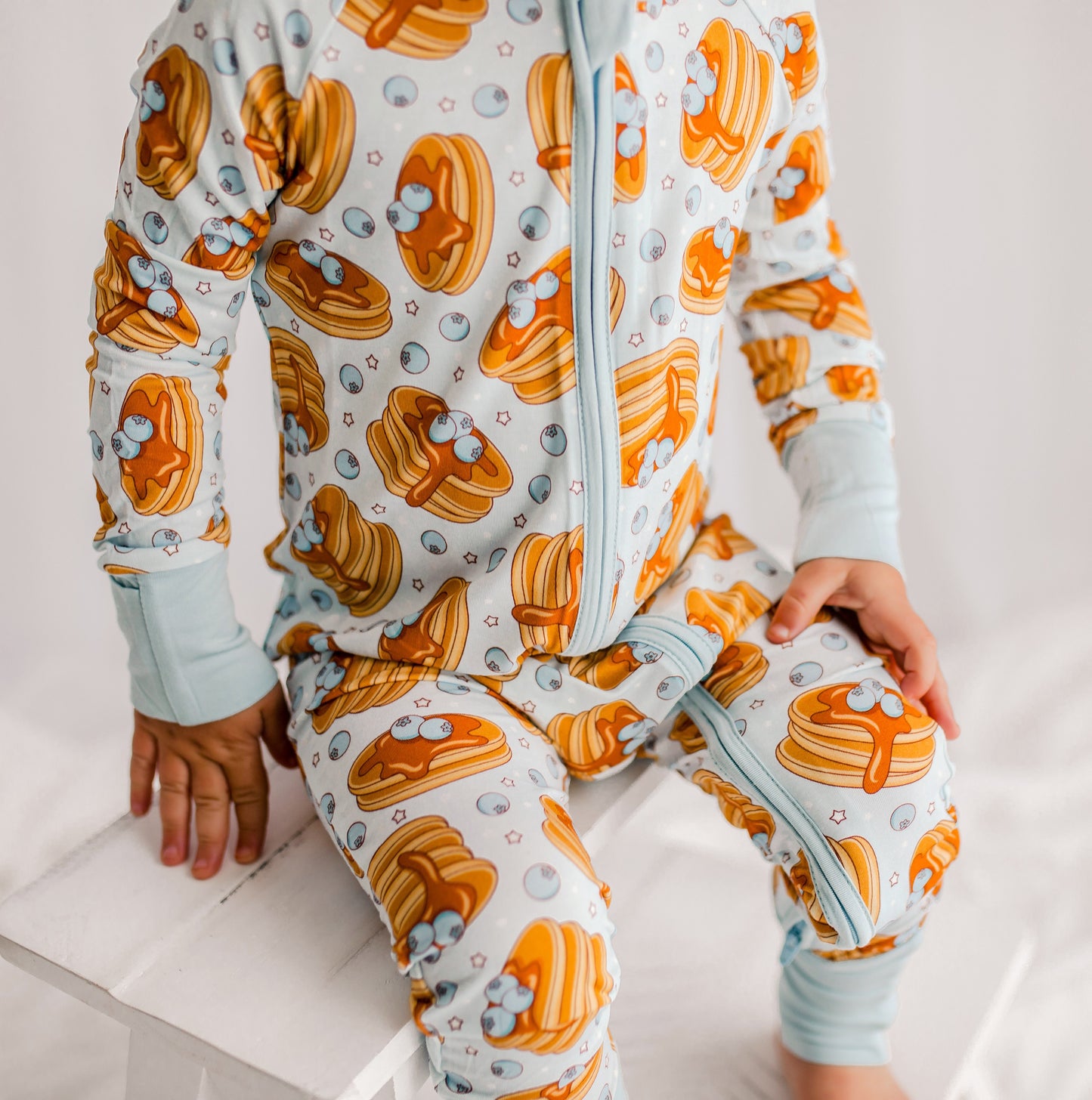 Light blue zippy romper with blueberries from Maine, pancakes with dripping syrup and stars 