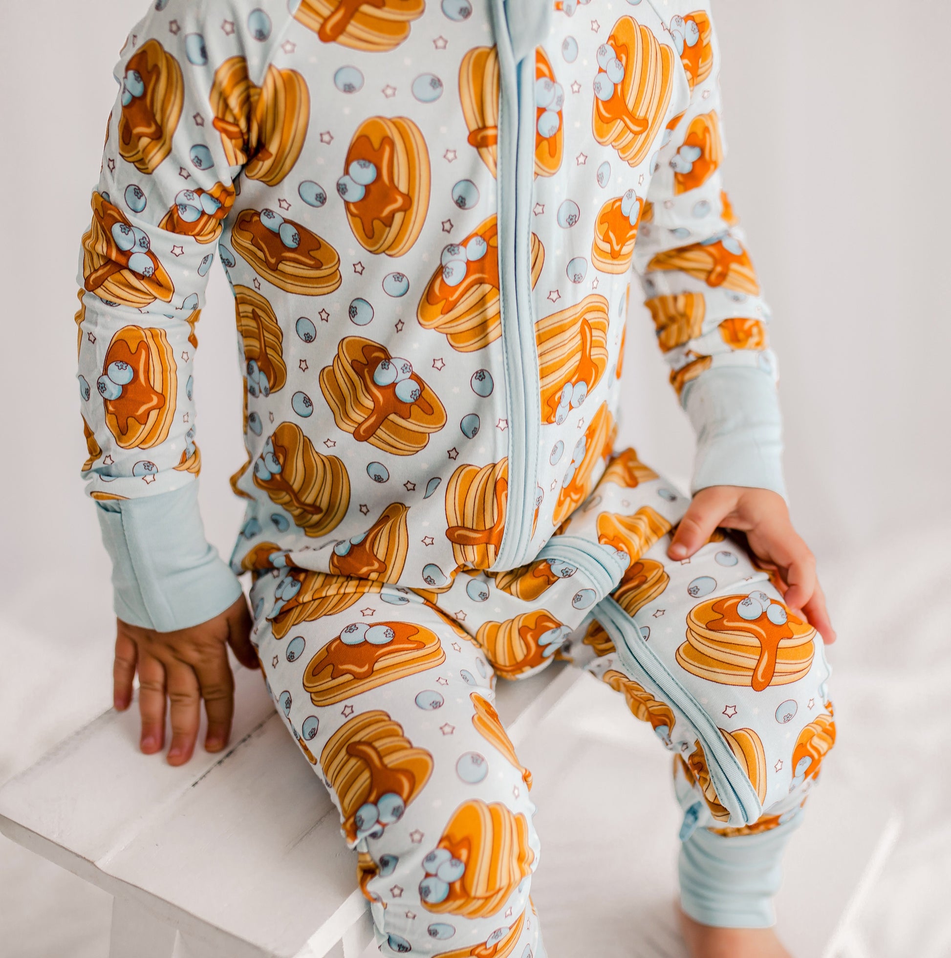 Light blue zippy romper with blueberries from Maine, pancakes with dripping syrup and stars 