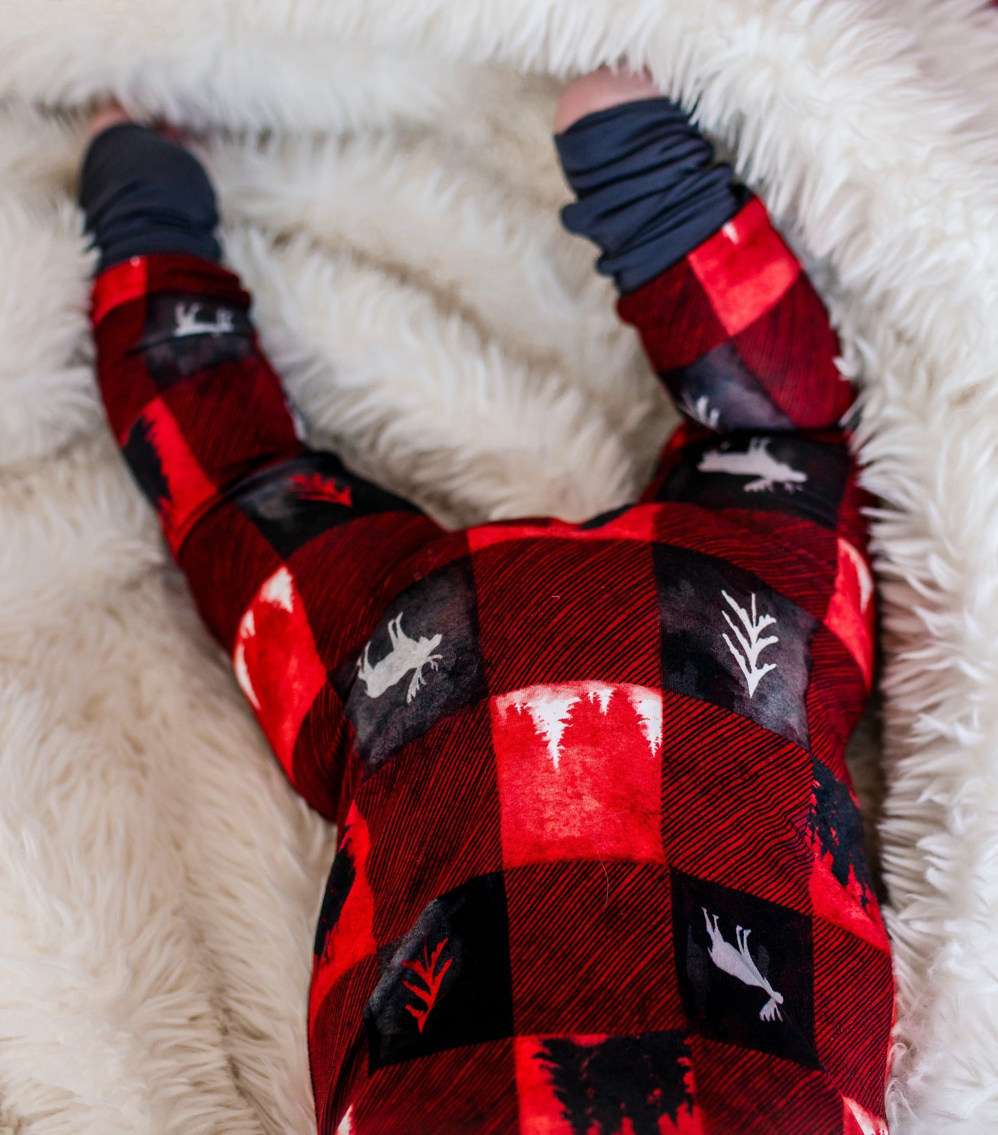 Red and black plaid zippy with nature-themed designs and the largest maine animal, the moose. 
