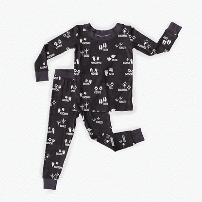 Charcoal pajama set with white wildlife tracks with the name of the animal in white   beside or underneath the tracks. 