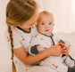 Two children in matching pajamas of Maine Lighthouses that are red and white with black accents 