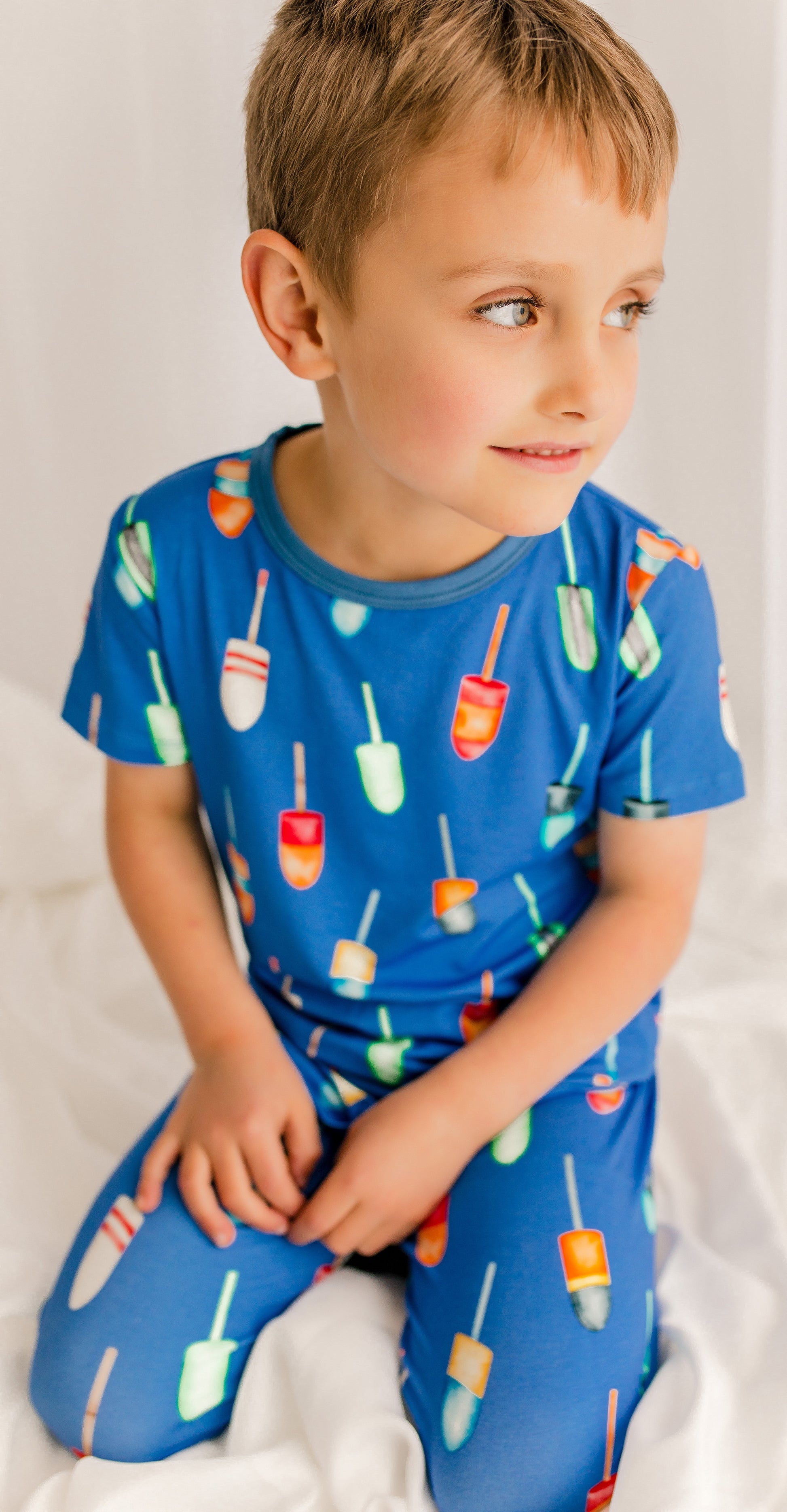 Child wearing family buoys of all different colors on a blue background 