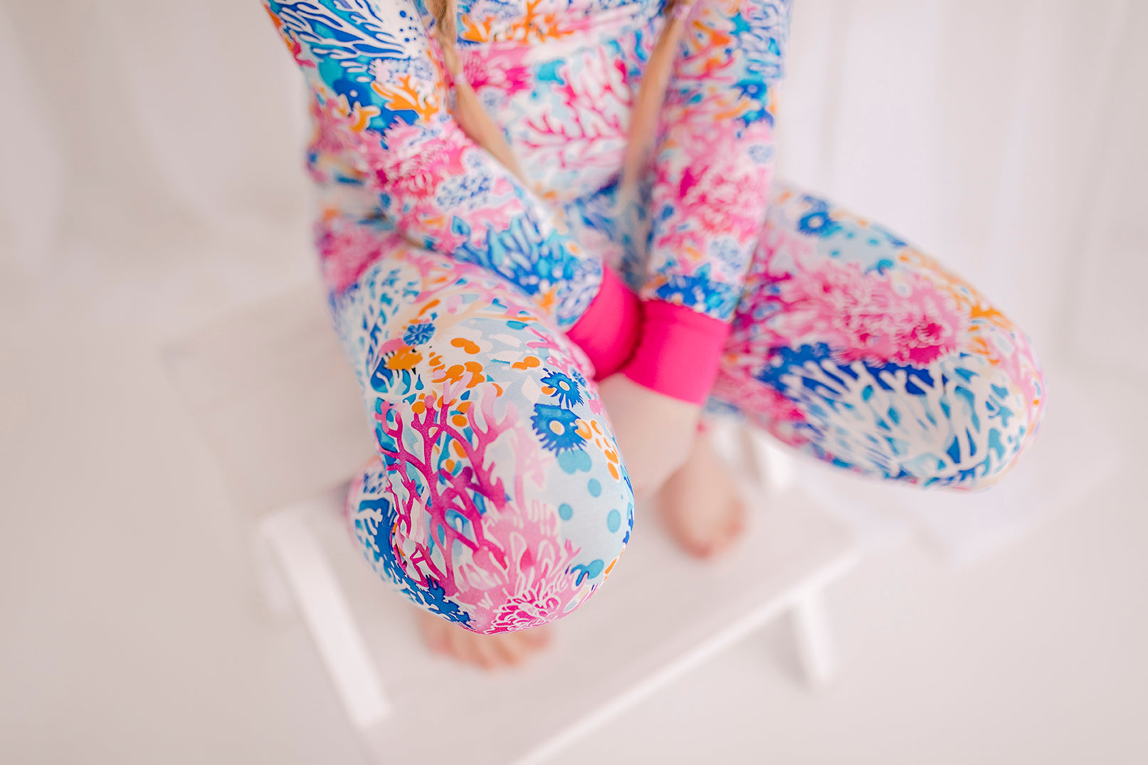 Maine coral reefs in all kinds of pinks, blues, and oranges on a white background with pink cuffs 