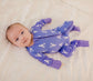 Child wearing a purple zippy romper with white Maine lobster pattern and purple cuffs 