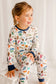 Child wearing pajamas with a pattern of animals, lobsters, fish, and more that all represent Maine for every letter of the alphabet 