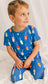 Child wearing a blue pajama set with all different color family buoys 