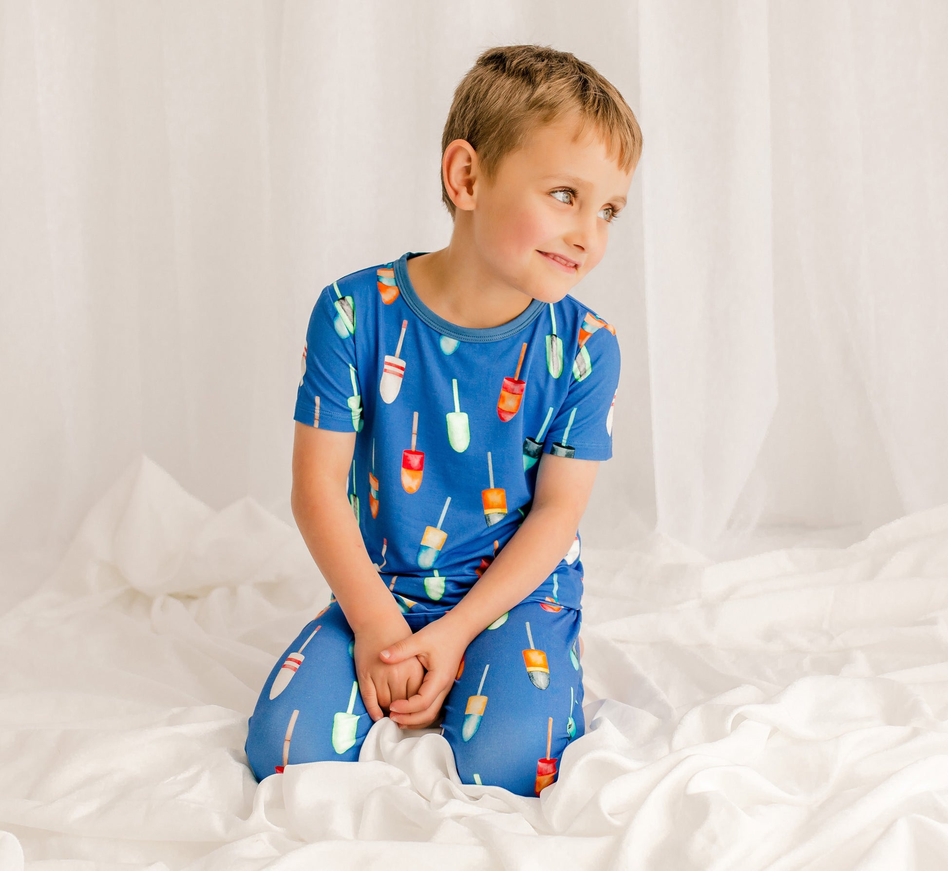 Child wearing blue pajamas with all different pattern buoys that are used in lobster fishing in Maine 