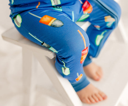 Child wearing blue pajamas with colorful designed buoys used in Maine lobster fishing 