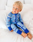 Child wearing light blue pajamas with Maine fishing boats with waves underneath, floating buoys, and seagulls 