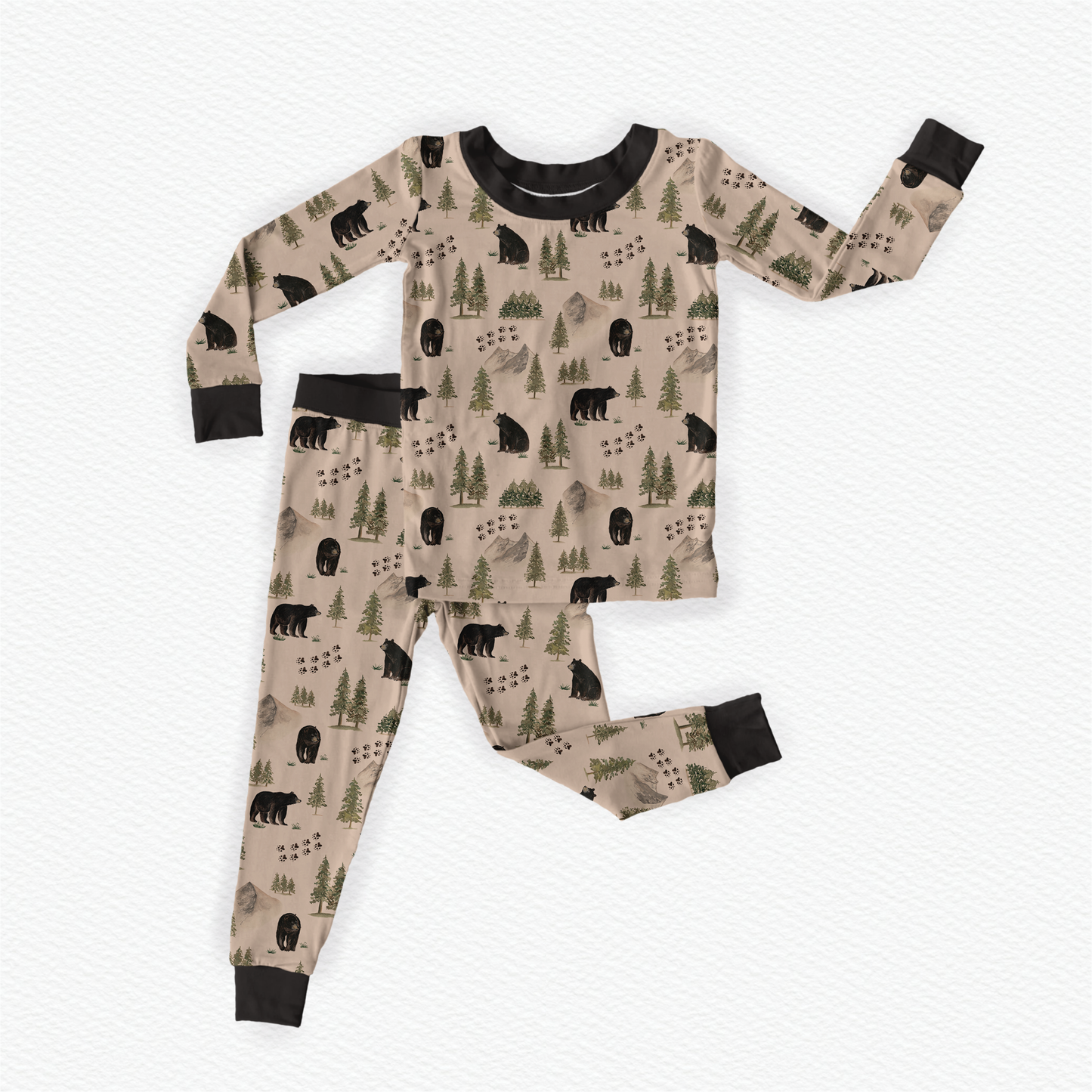 Children's pajama set with bears, vast gray mountains, green trees, and animal tracks on a beige background with black accents