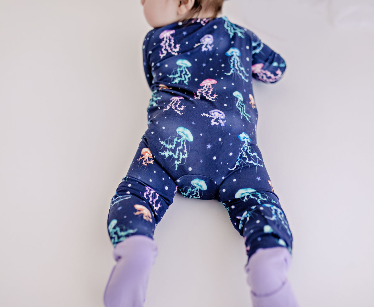 Infant wearing floating jellyfish from the ocean in all different colors with purple accents 