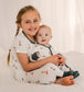 Two children in matching pajamas of Maine Lighthouses that are red and white with black accents 