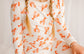 Young girl wearing a white pajamas with the Maine orange lobster patterns all over 