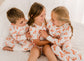 Three children in matching pajamas with orange Maine lobsters 