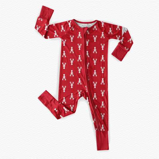 A red romper suit with a pattern of white lobsters featuring long sleeves and a zipper at the front.