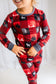 Red plaid themed pajamas with black and red squares with white moose and white and black trees and gray accents 
