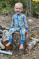 Child in a blue, yellow, and white patterned floral one piece of the Maine wildflowers 
