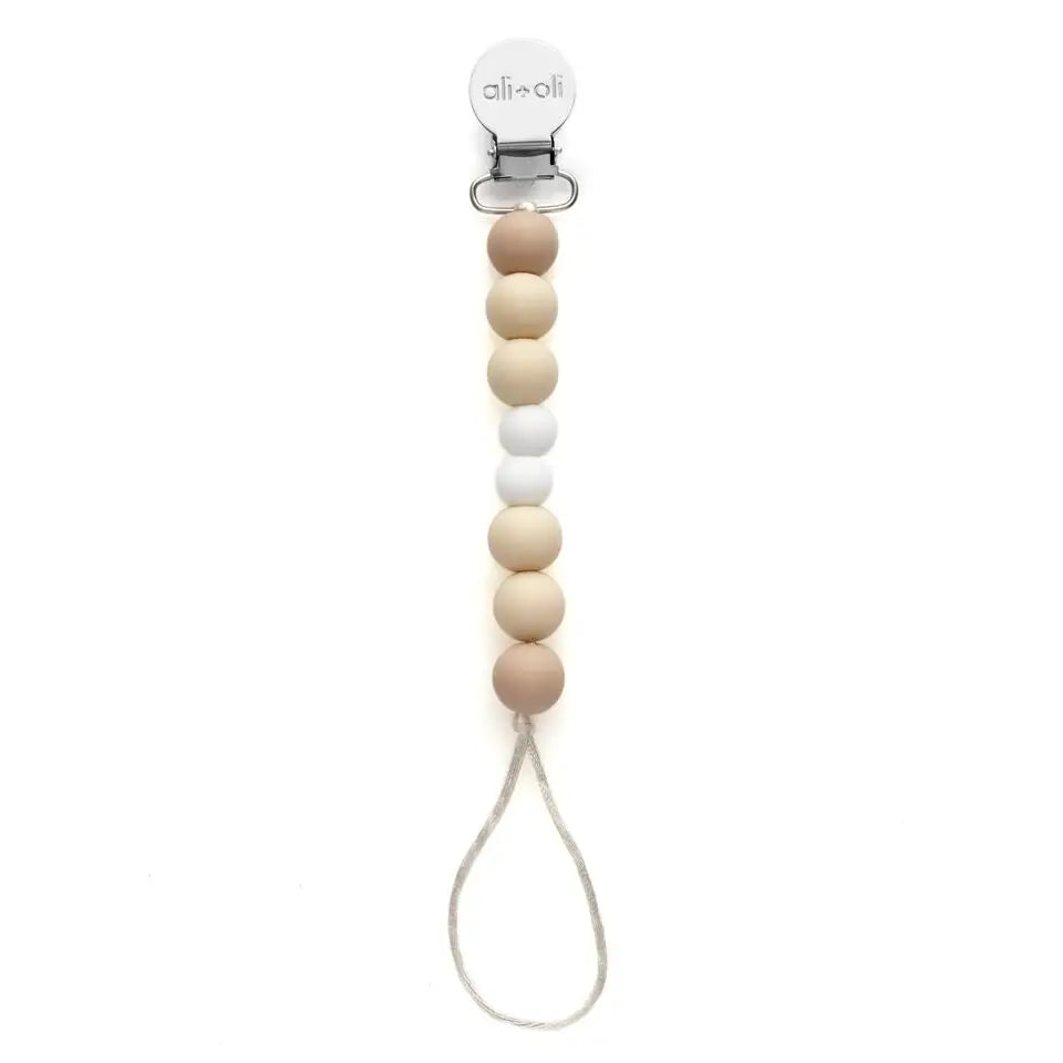 Wooden pacifier clip with beige and white beads on a white background